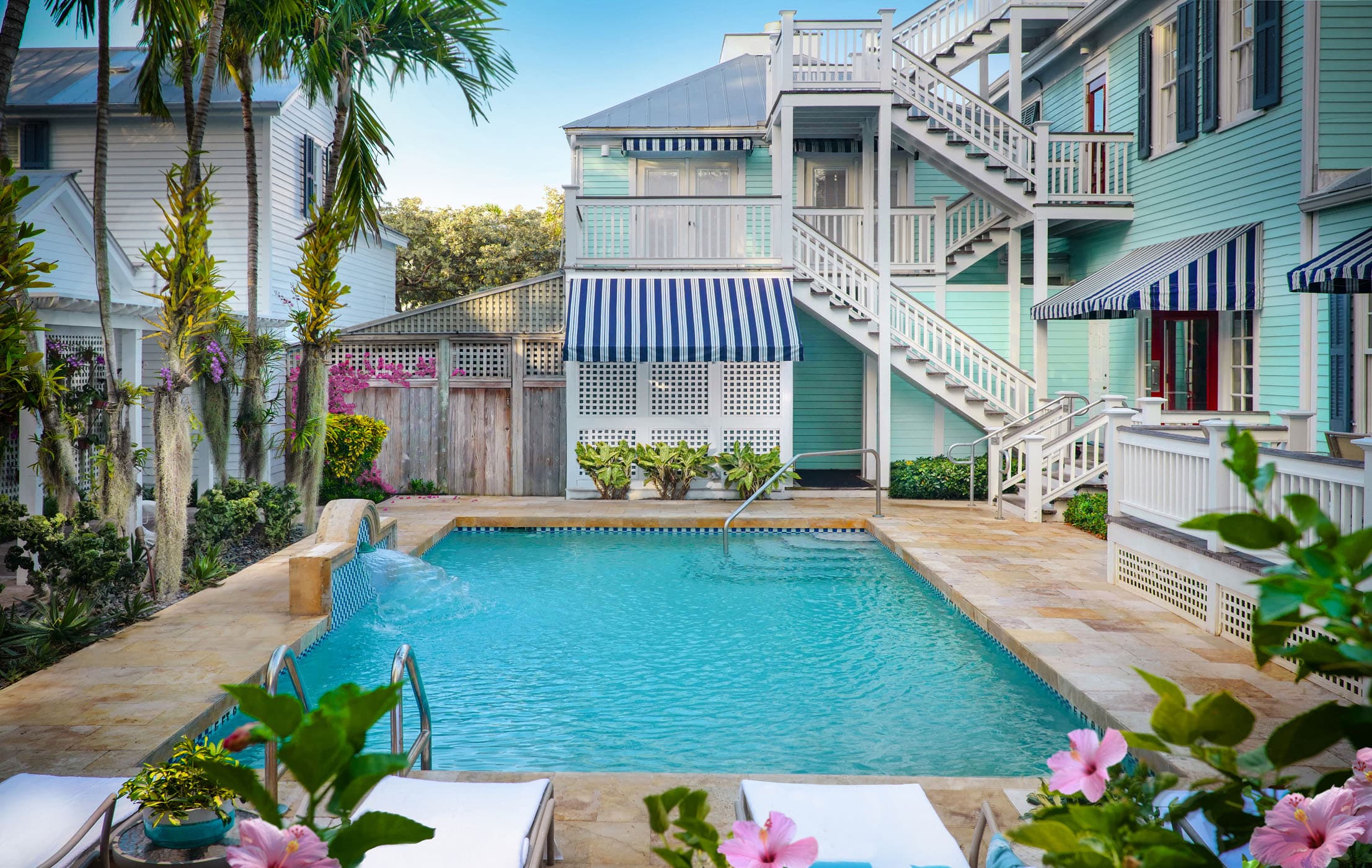 The pool with lounge chairs and pink flowers at Marquesa