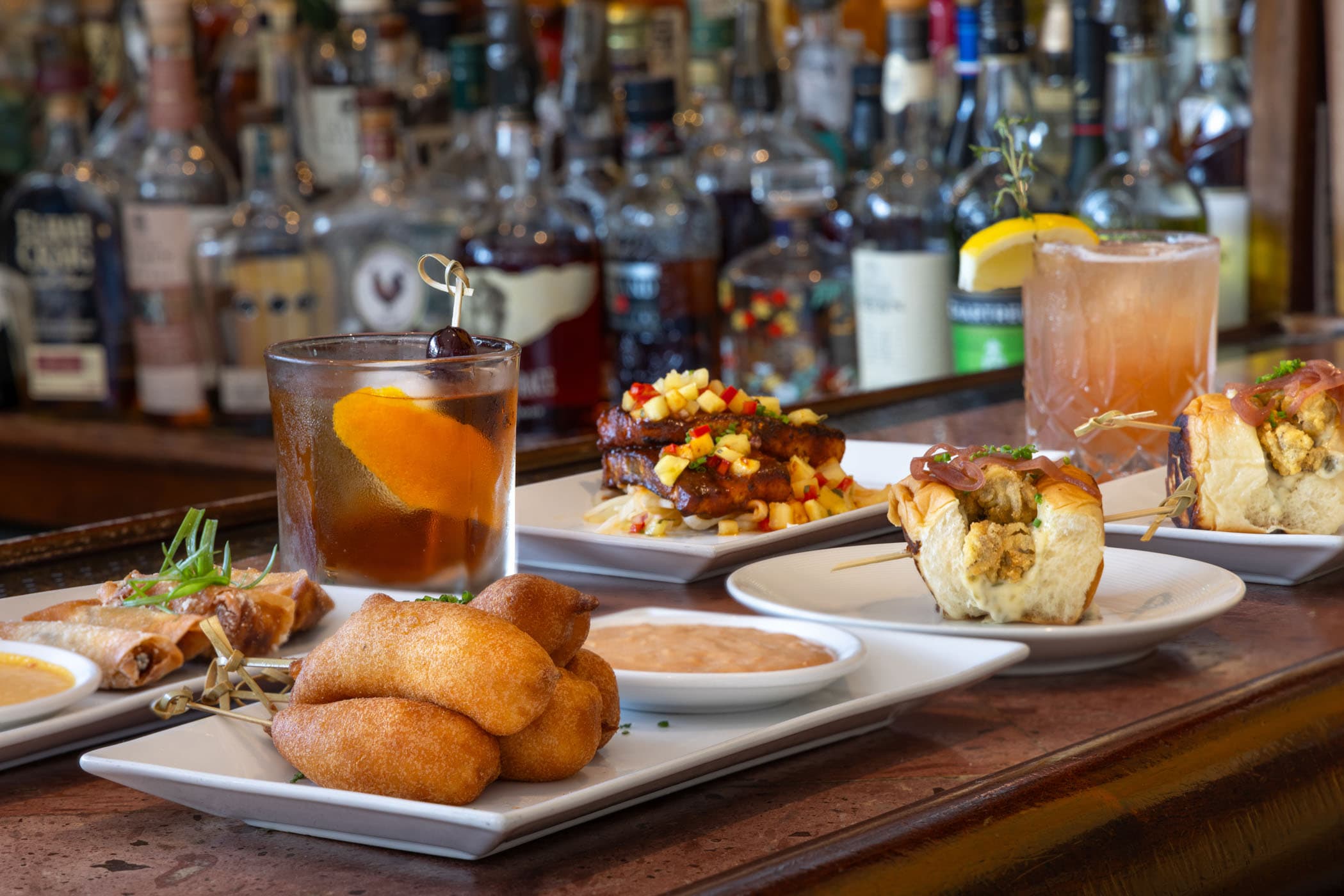 Corn dogs, spring rolls, cocktails and other dishes at the bar at Marquesa