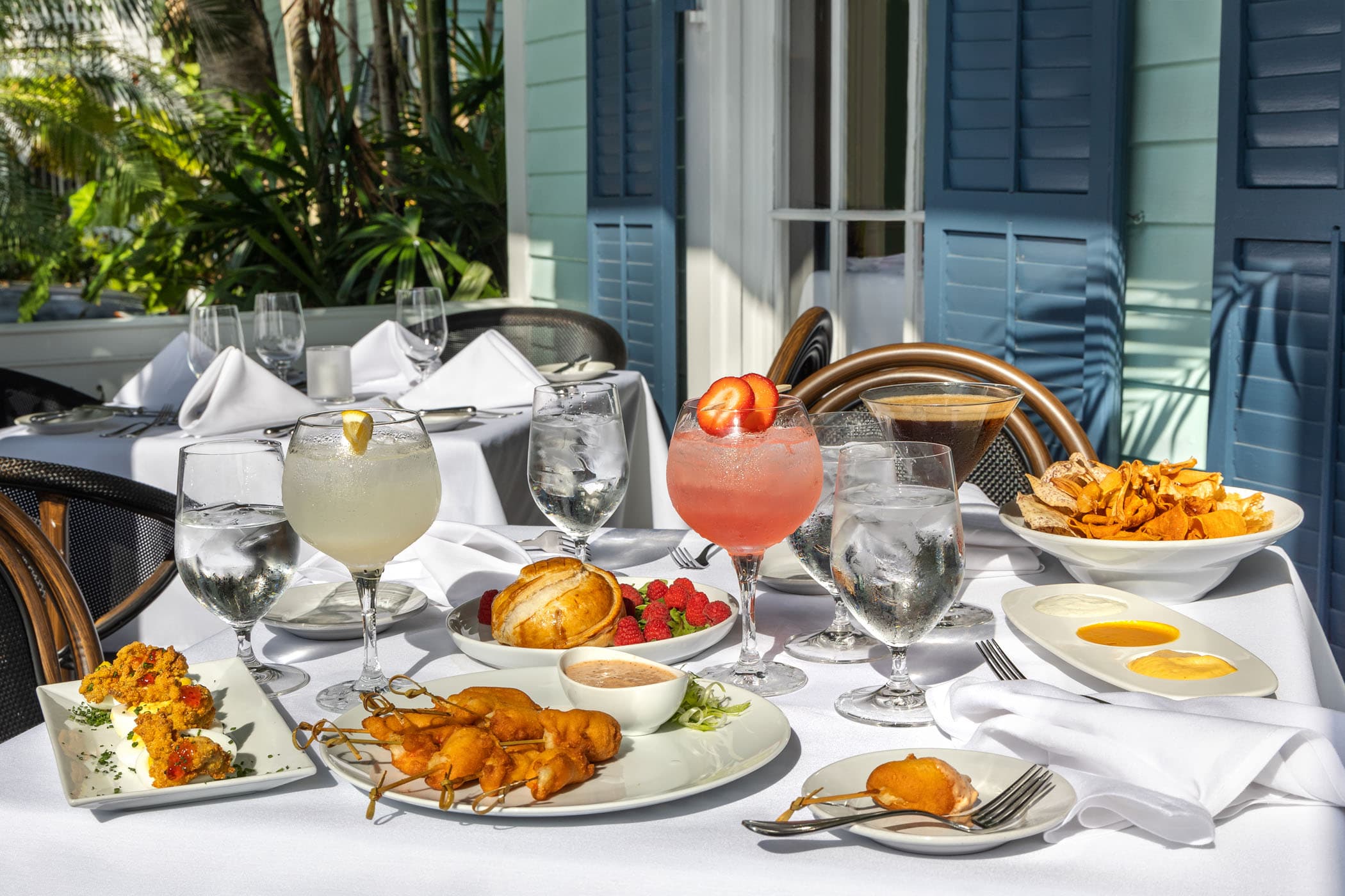 A beautiful spread of food and cocktails on the patio at Marquesa