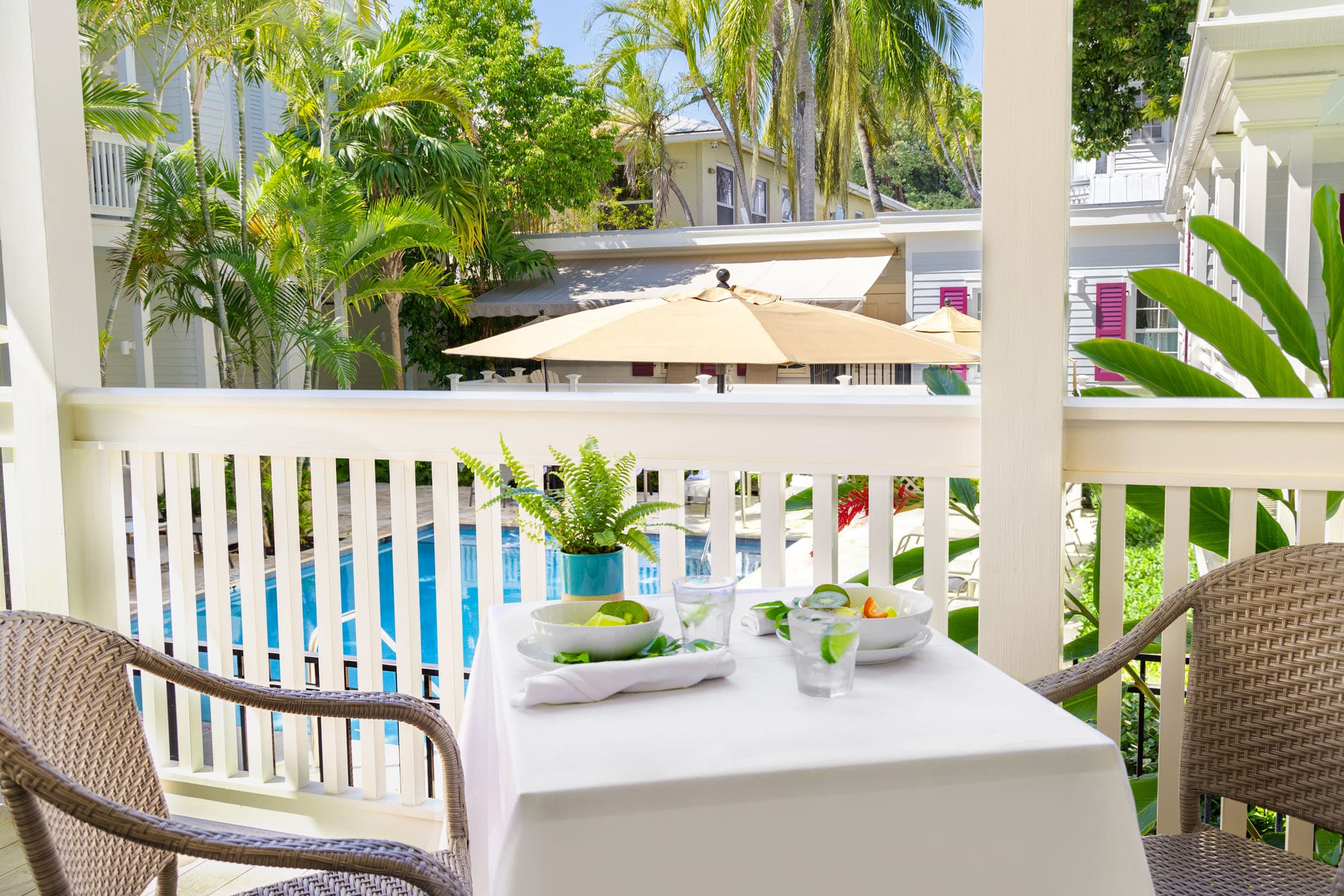 A balcony with a patio table overlooking the pool at Marquesa